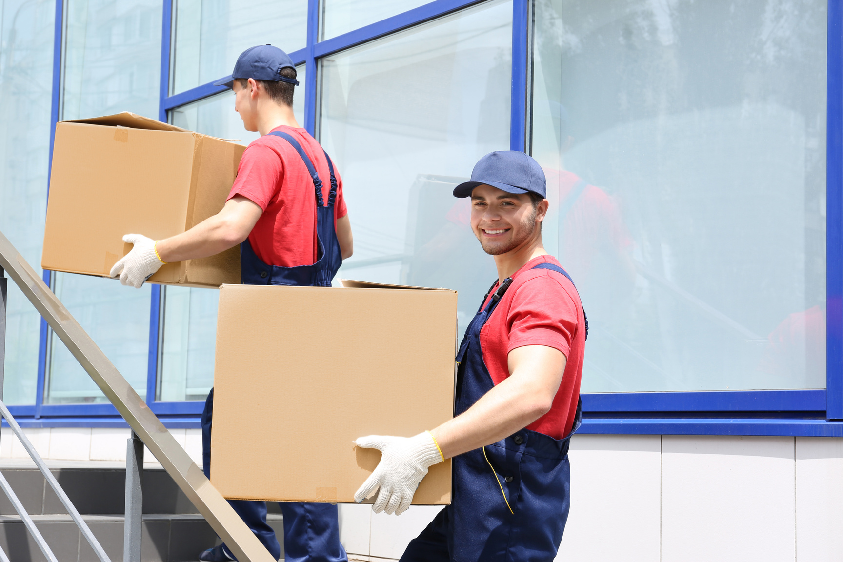 Zwei Möbelpacker tragen Umzugskisten in die Wohnung